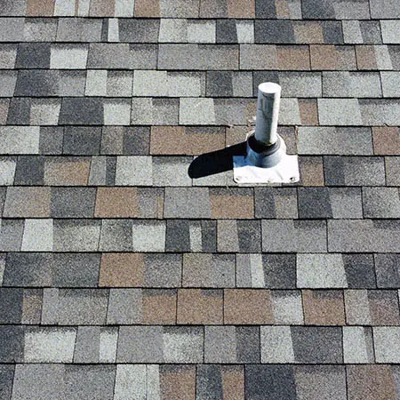 closeup of the shingles and plumbing vent on the roof of a house