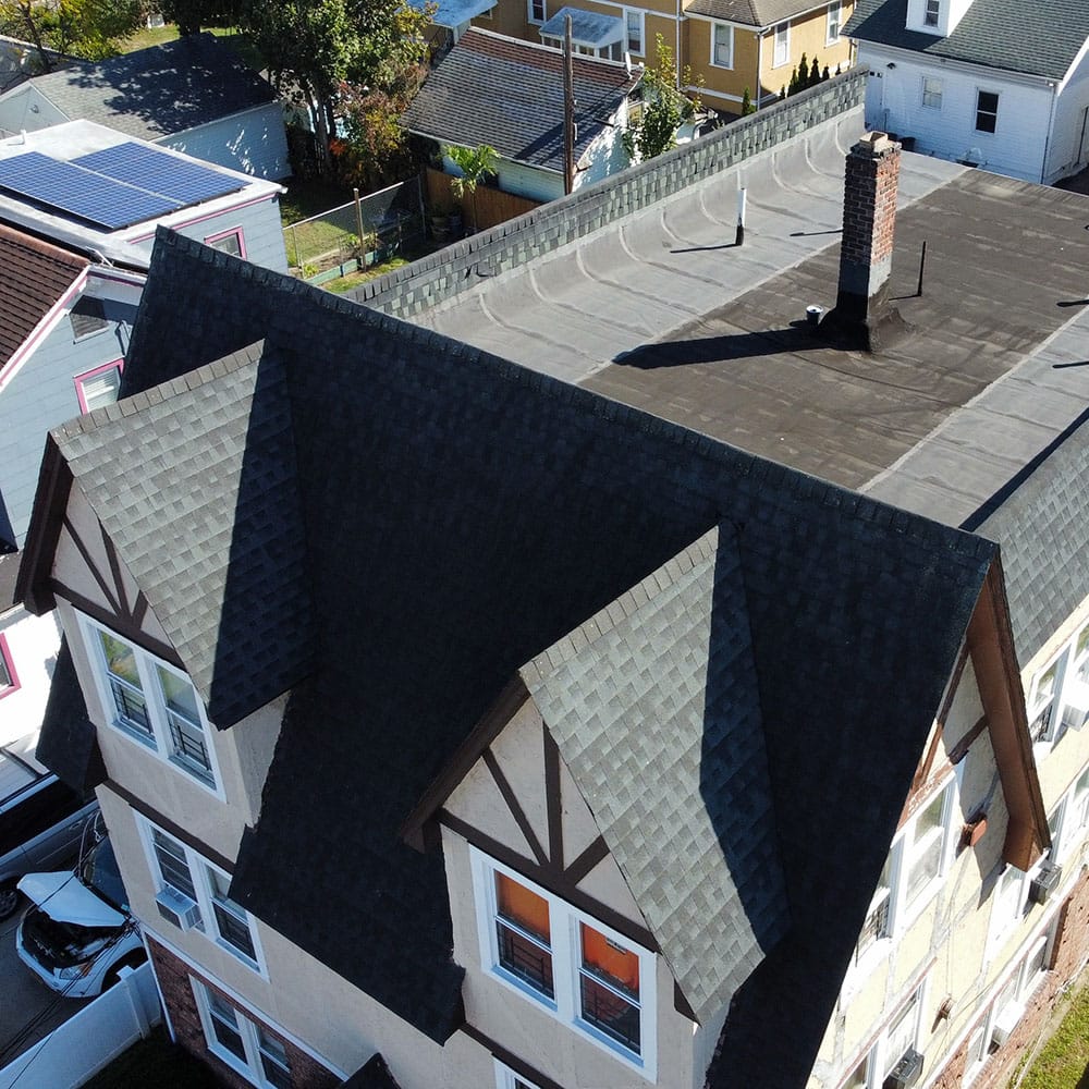 Aerial drone view of a 6-unit apartment building roof showing asphalt shingles with rolled asphalt on the flat areas.