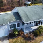 Aerial drone photo of an older Long Island home showing roof condition and attached garage