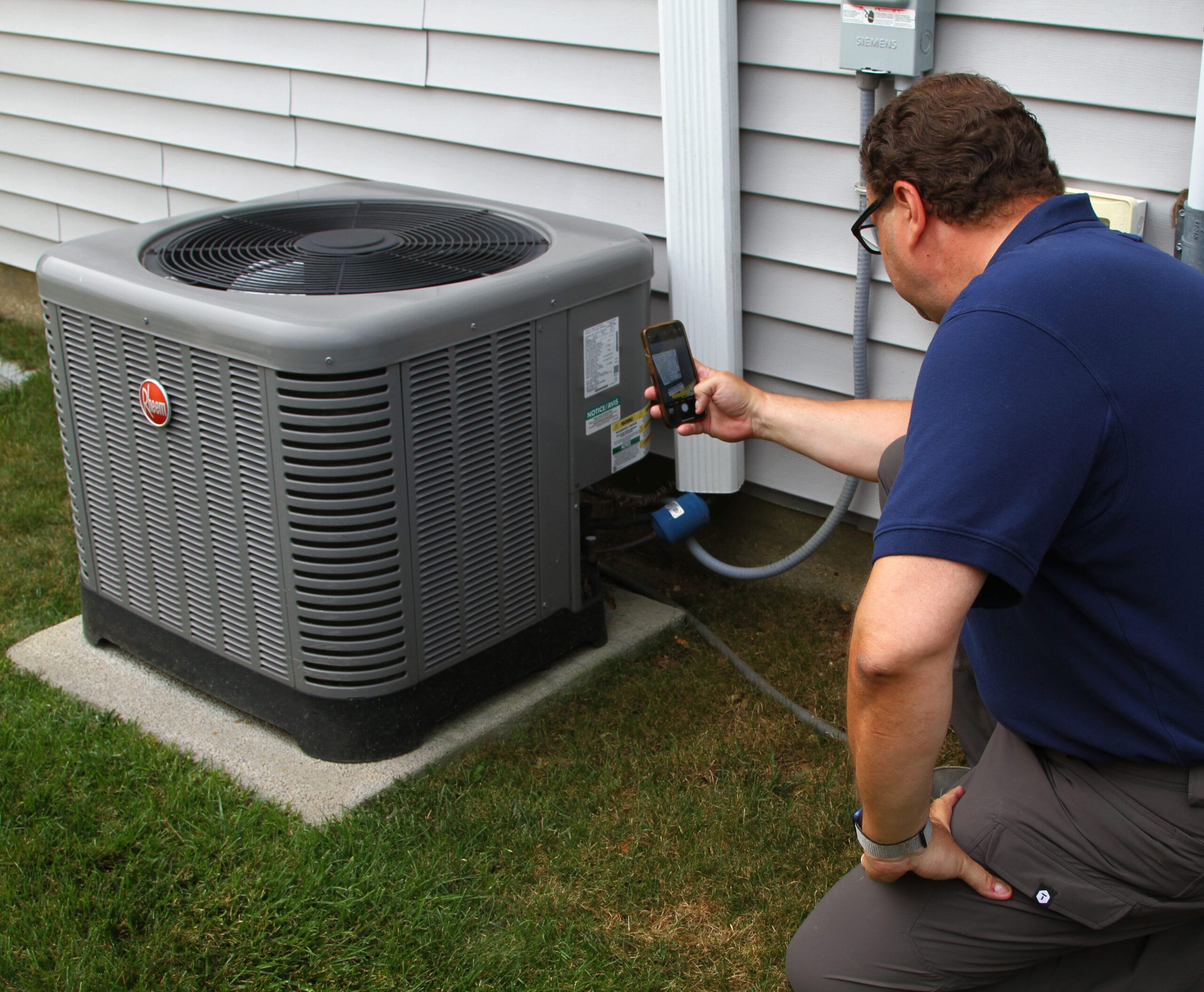inspector in kitchen pointing thermal camera at stove